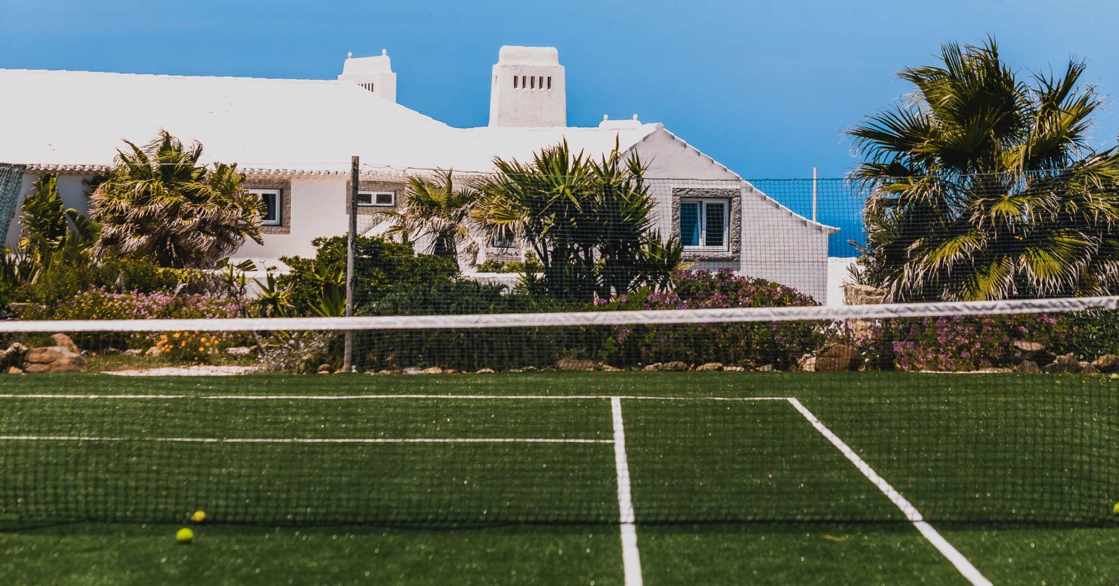 Tennis court at luxury whitewashed Portuguese villa