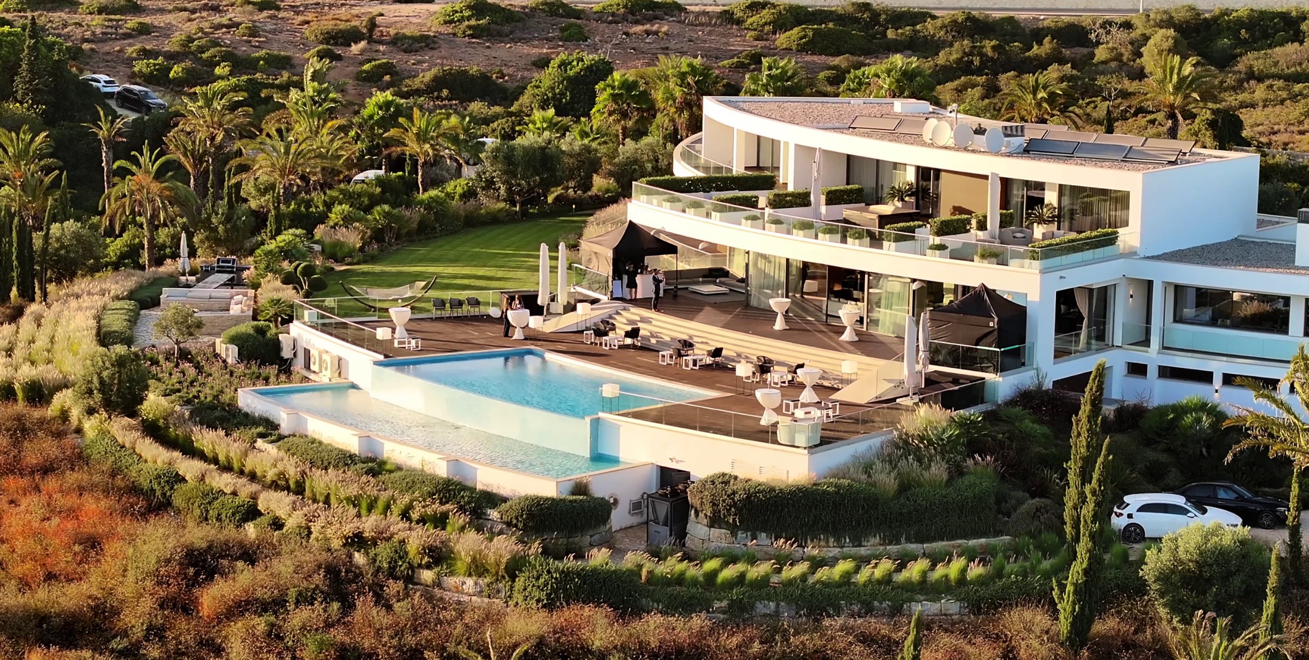 Aerial view of modern luxury villa with infinity pool and landscaped Mediterranean gardens